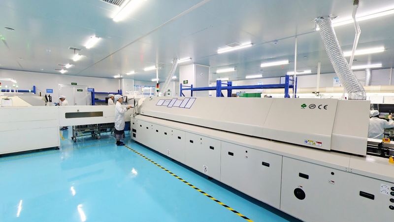 SMT production line with reflow oven and operators